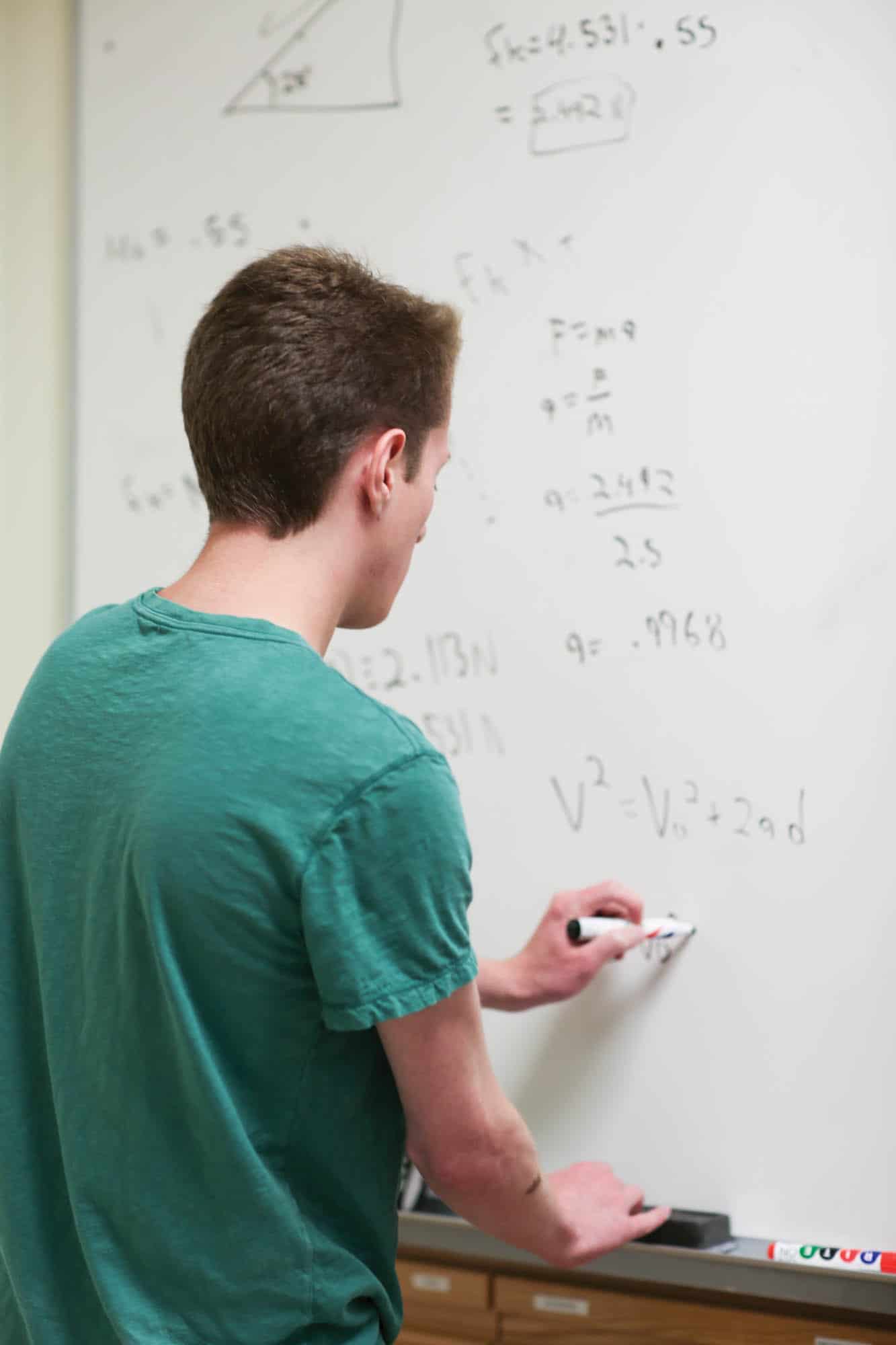 student doing mathmatics on class board