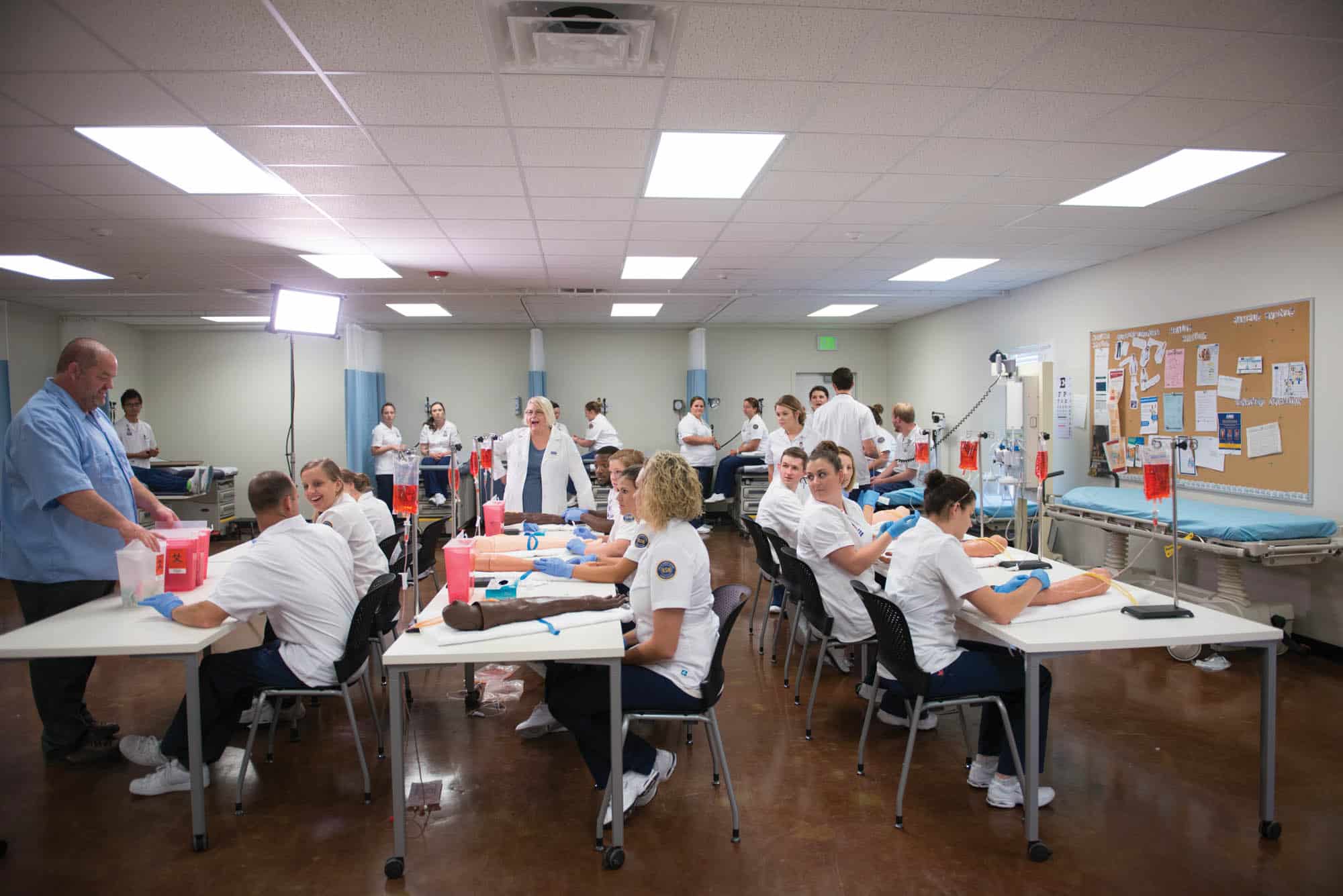 A group of nursing student in the classroom performing a procedure.