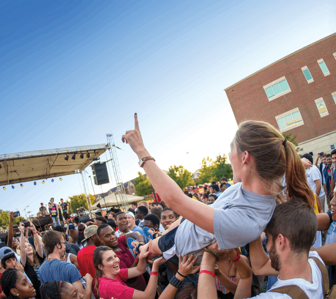 a female student is carried by the crowd.