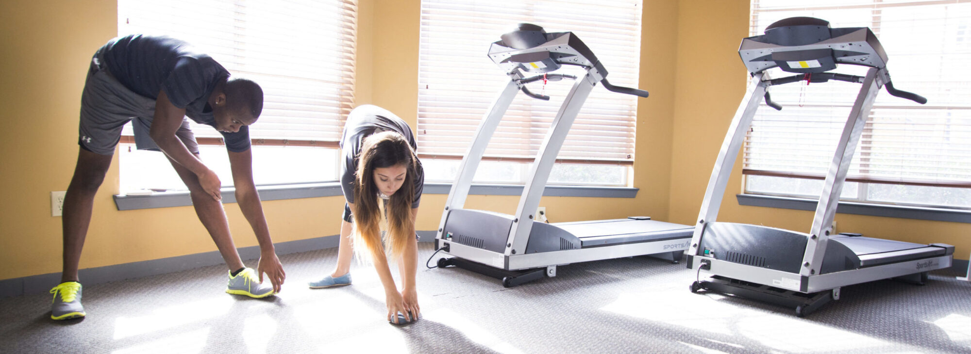 Two students scratching during exercise class. 