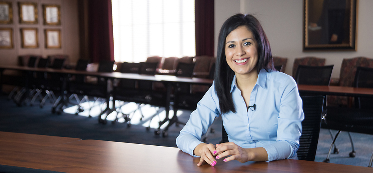 Woman sitting in boardroom.