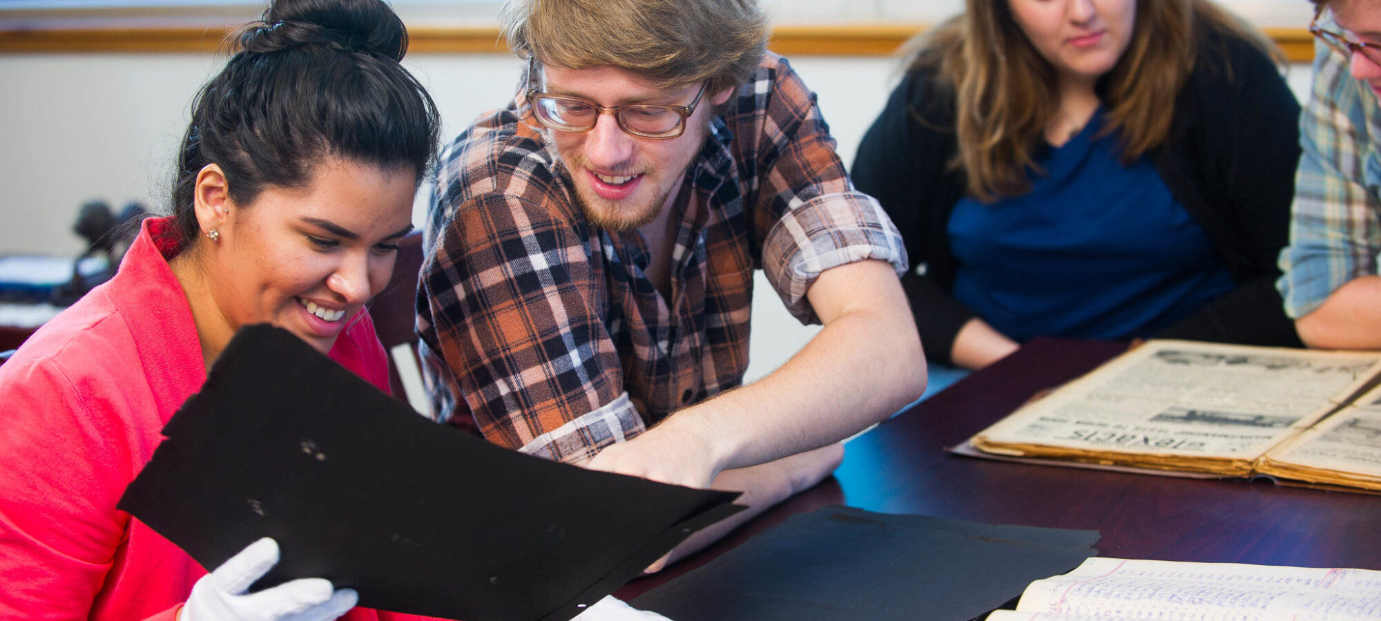 Group of students looking over written artifacts.