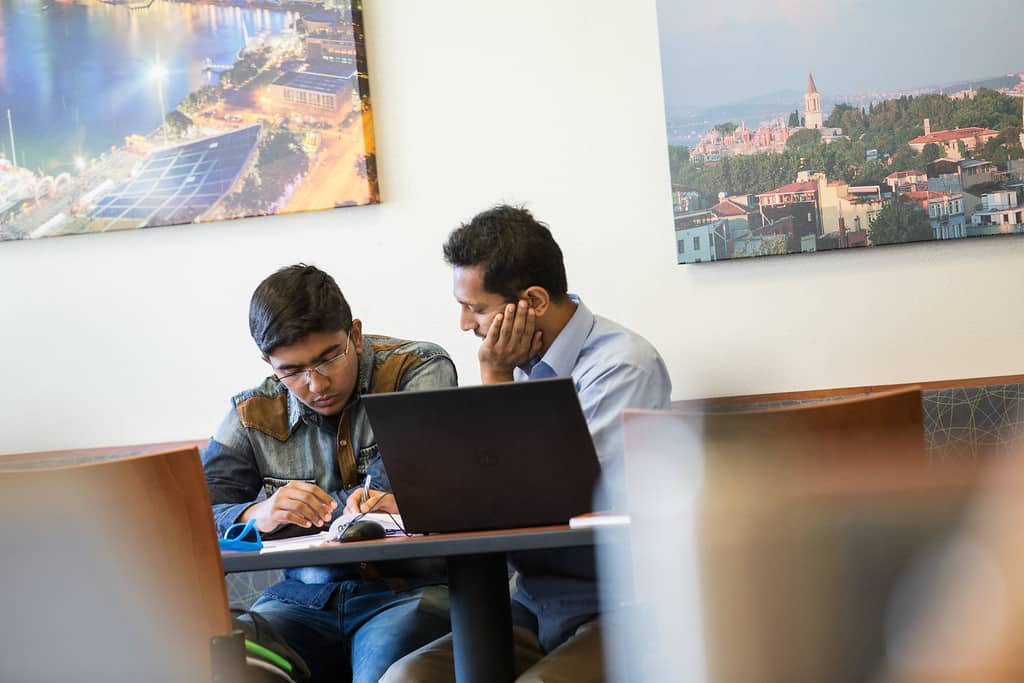 Professor helping student at table