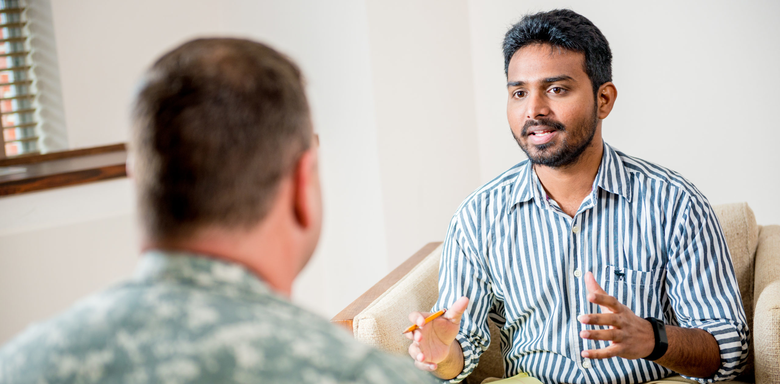 Social worker talking to man in the military.