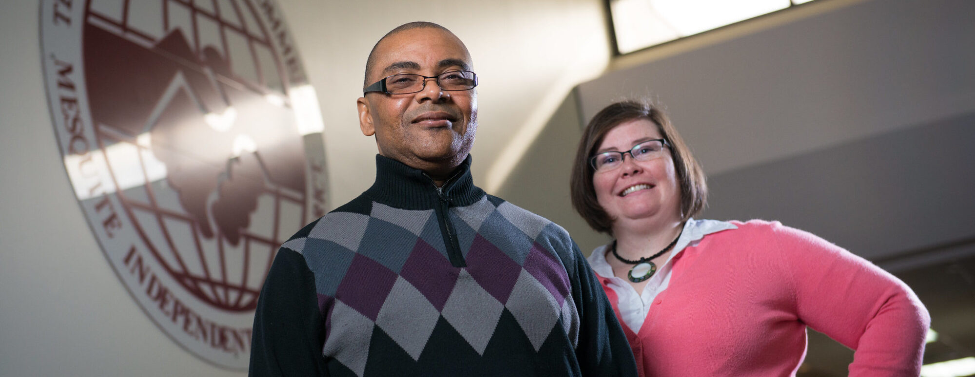 Two people standing on stairs at community college.