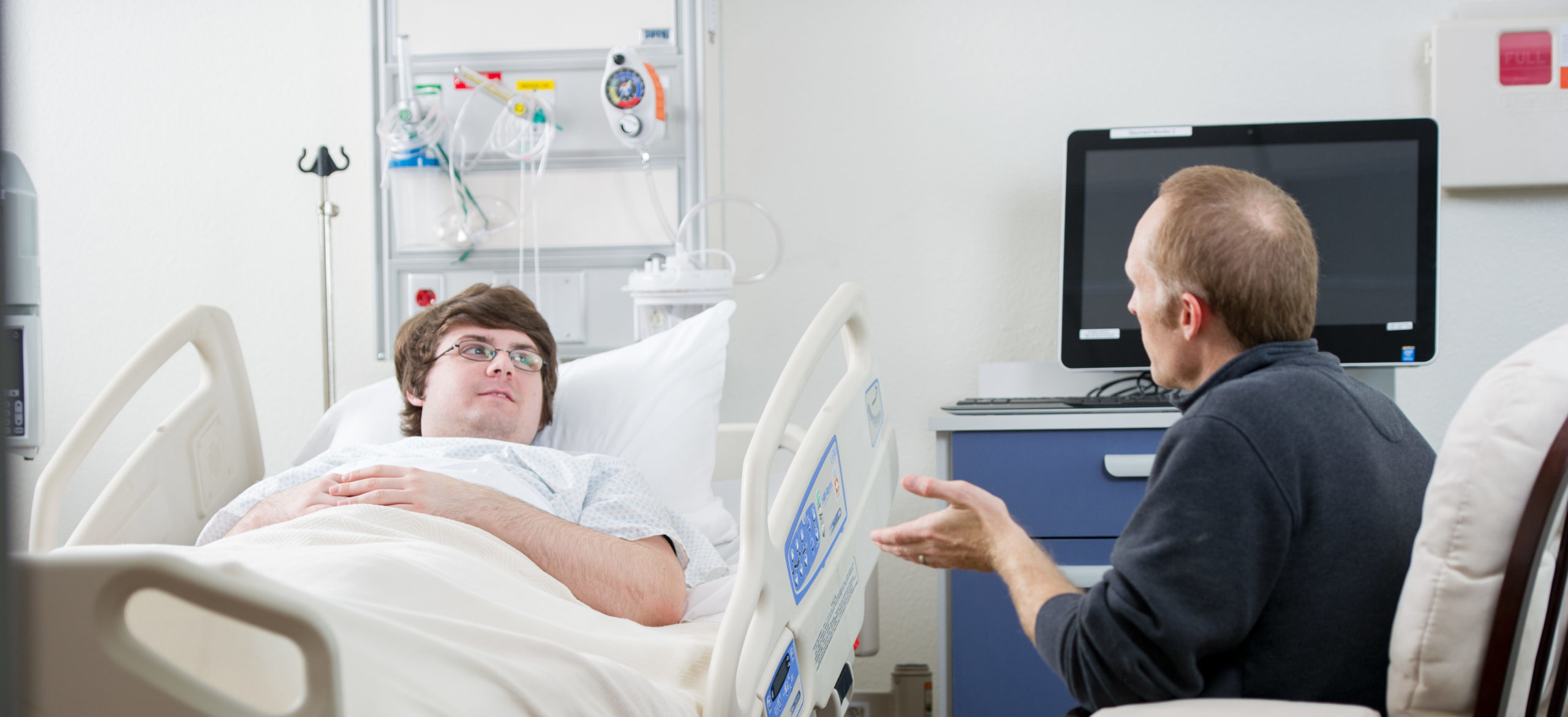 Social worker talking to man in the hospital.
