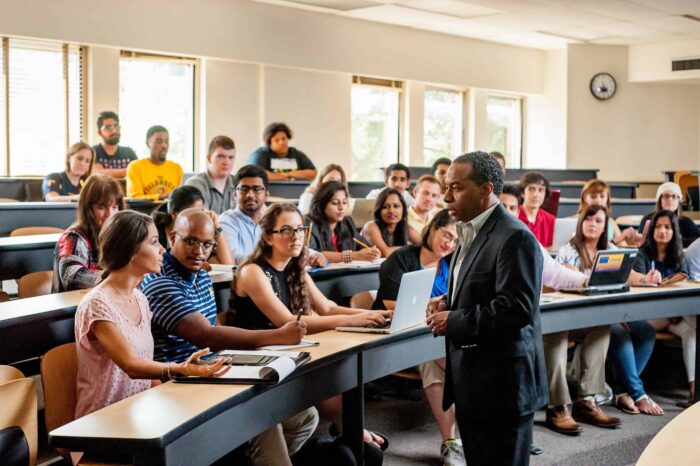 Student interacting with professor in a classroom