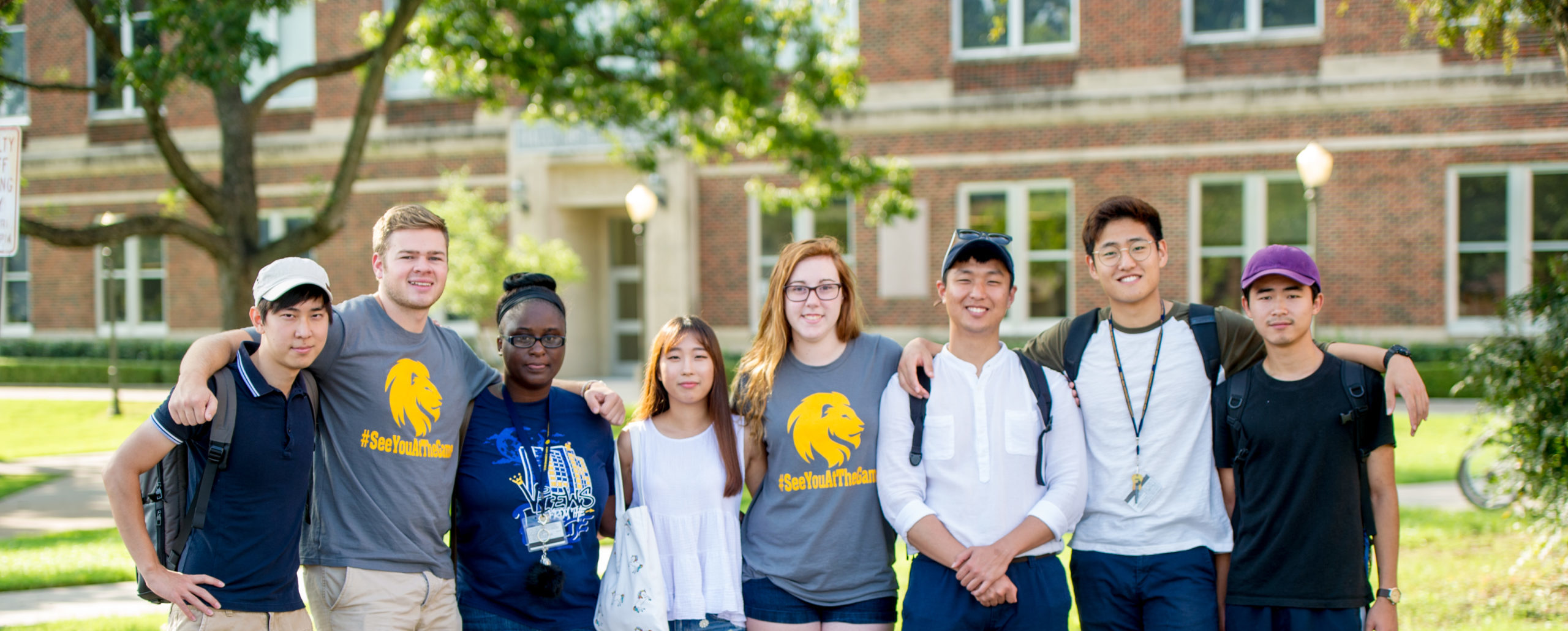 A group of eight A&M-Commerce students friendly hugging each other for a photo.