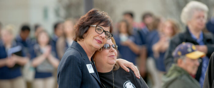 Two women hugging at a veterans vigil.