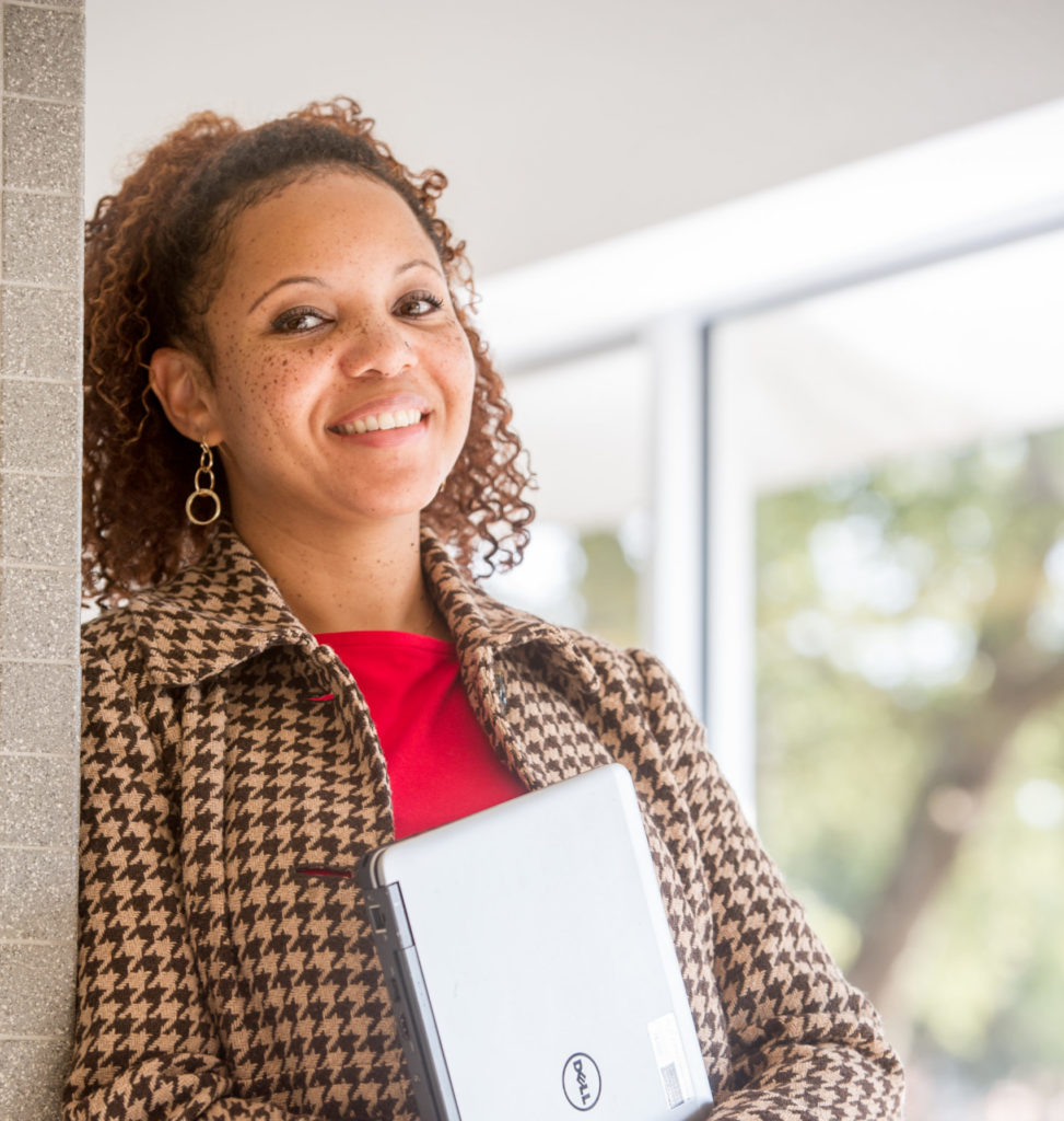 Woman holding a laptop.