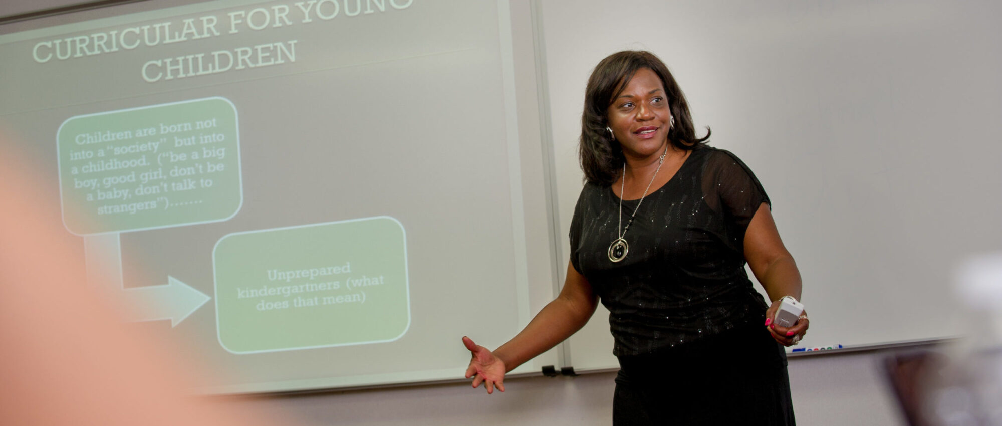 Woman giving presentation to a class.