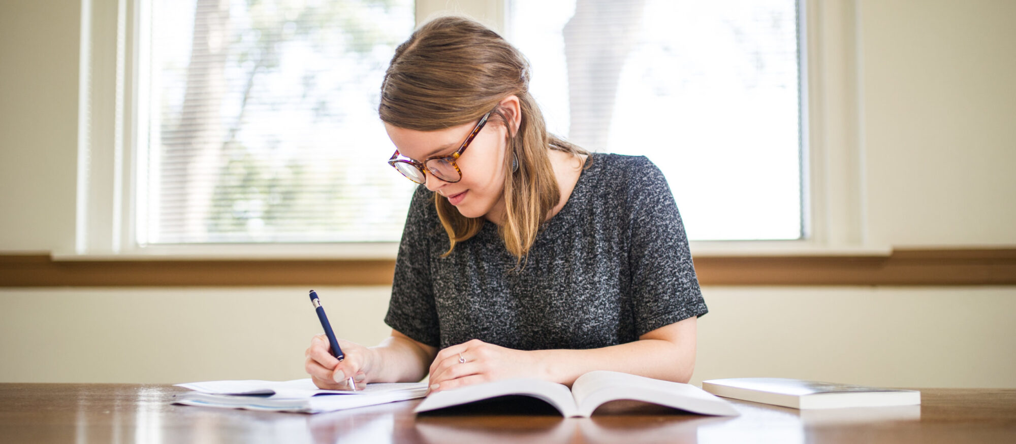 Woman writing at a table. 