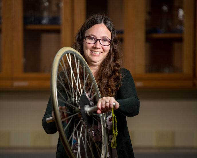 Photo of Robynne Lock holding a bicycle tired used for an experiment.