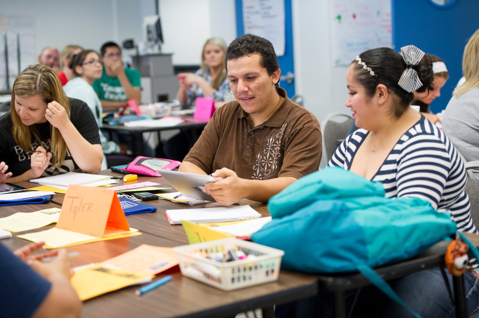 Classroom environment with adult man and woman at table with construction supplies.