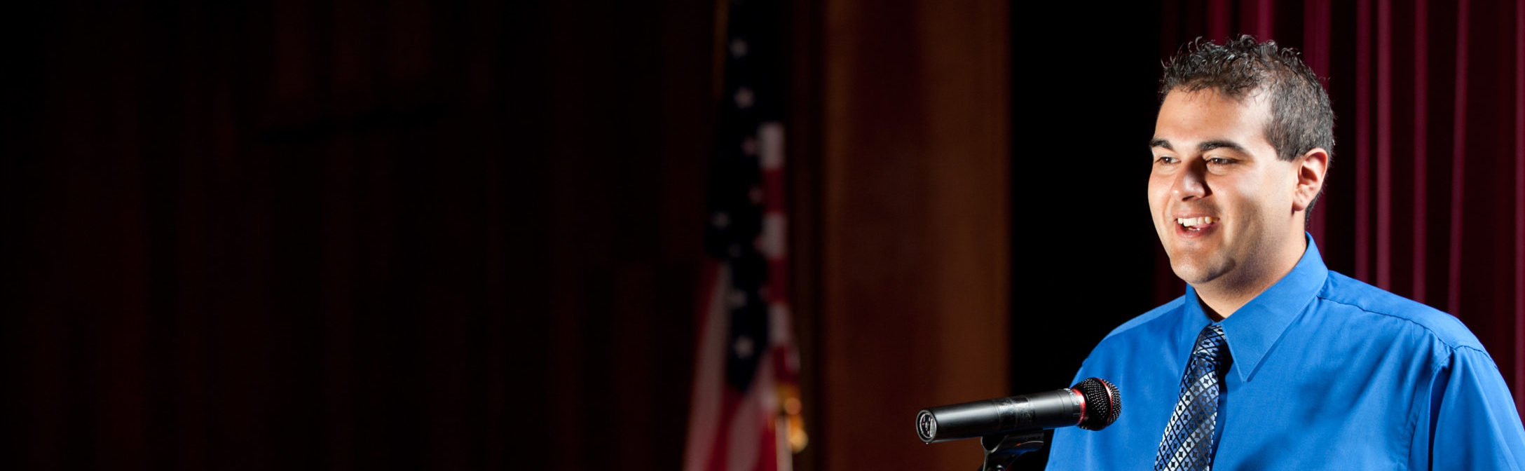 Man speaking on stage at a podium