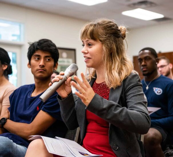 Student speaking holding a speaker.