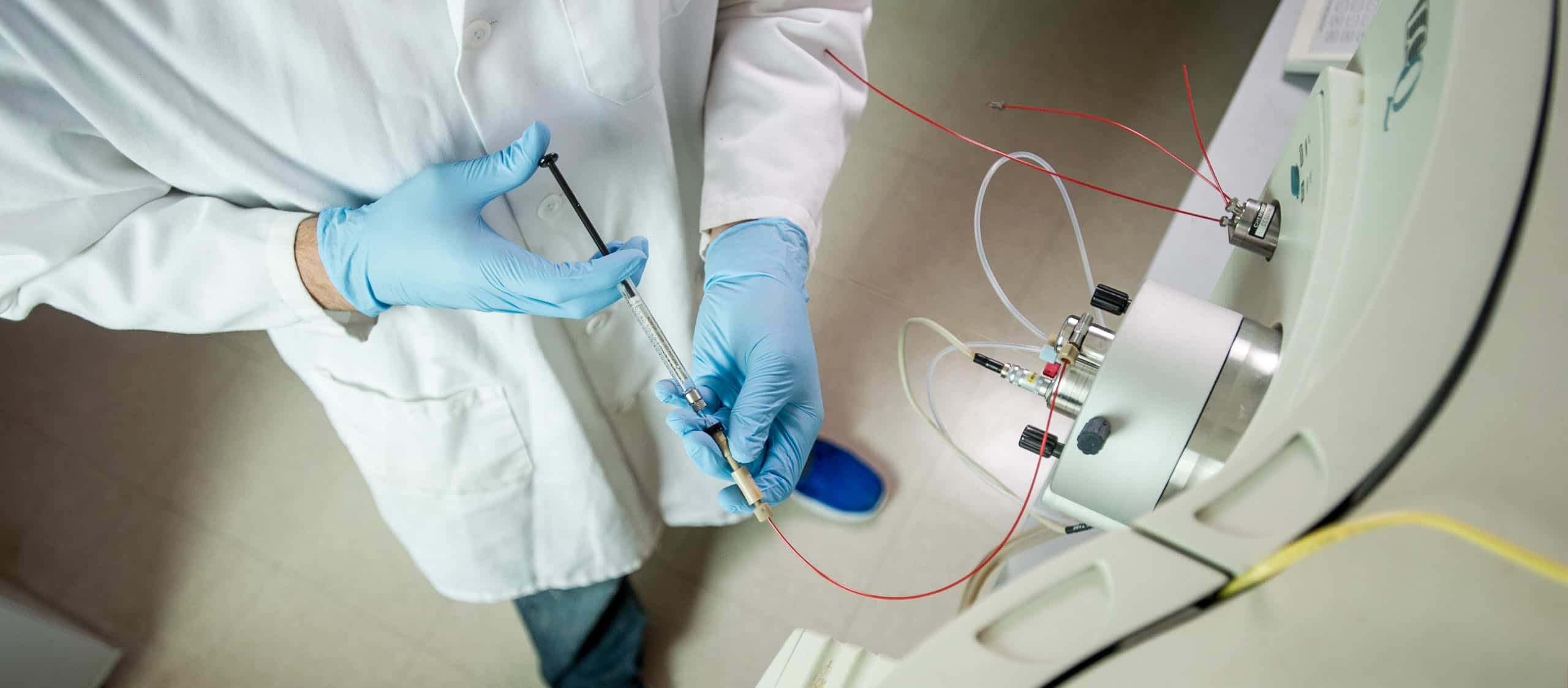 Chemist injecting fluid into a large mechanical system