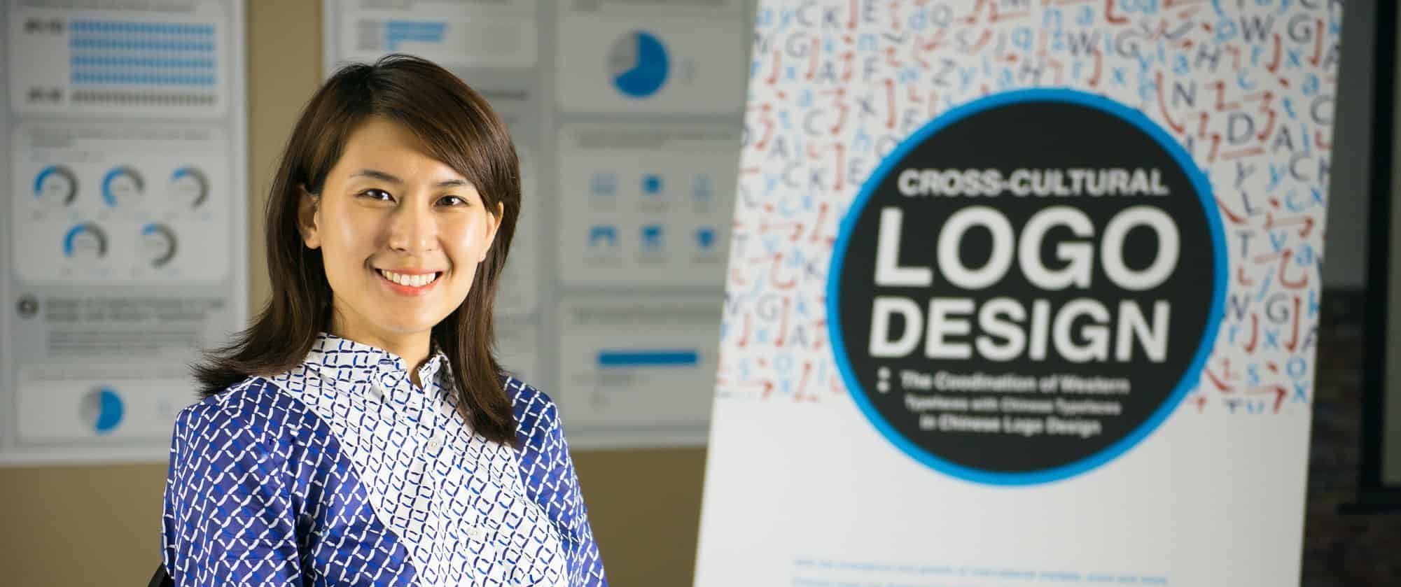 Woman sitting in front of logo that says, logo design