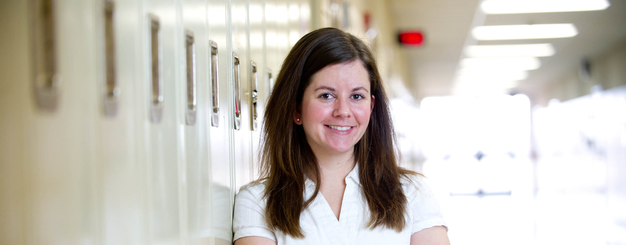 High school teacher standing in a hallway.