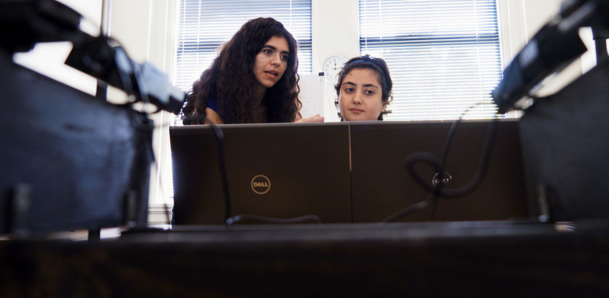 Two females, one is teaching the other something about the computer.