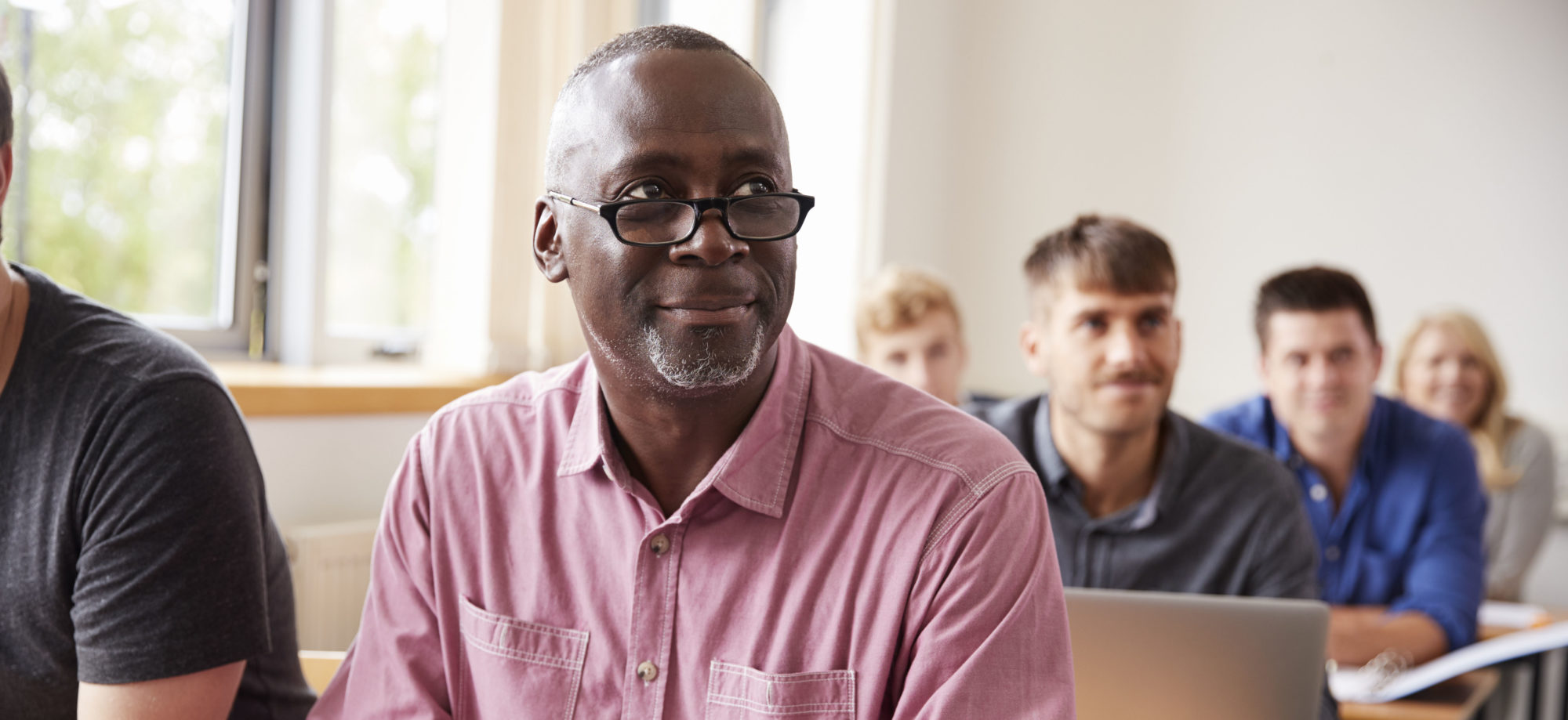 Mature Student Using Digital Tablet In Adult Education Class.