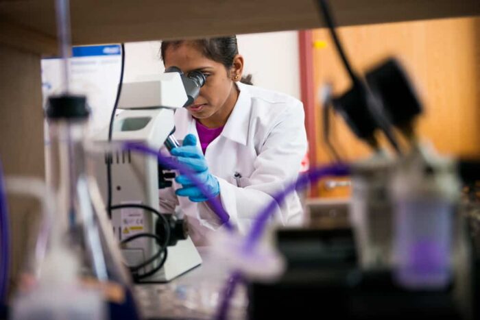 Student looking into Biological Microscope