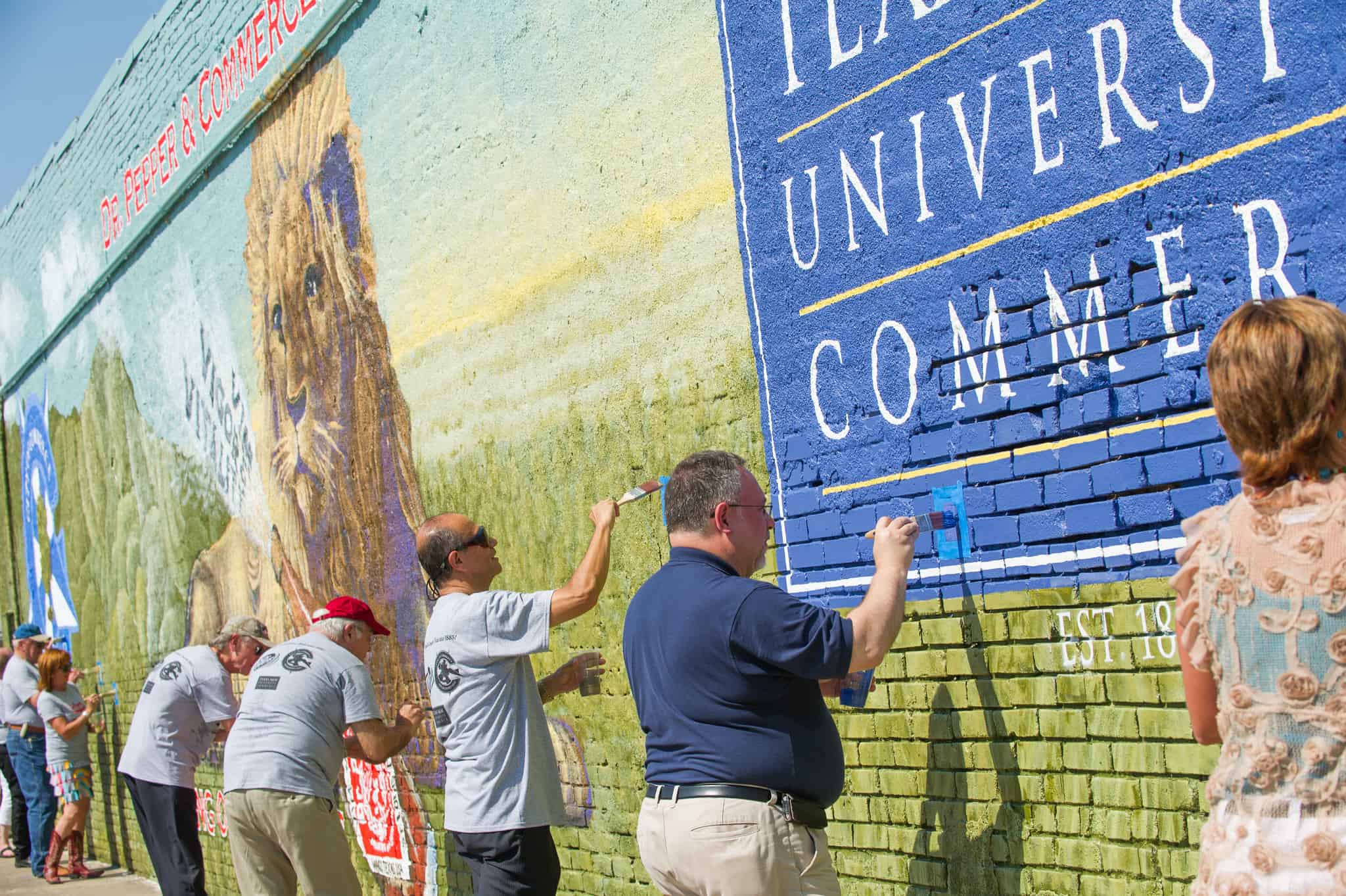Group gathers to finish the Dr Pepper mural.