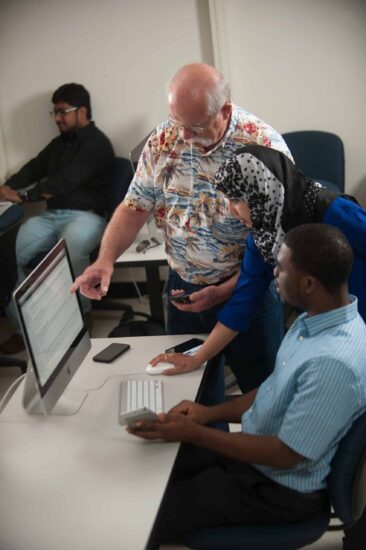 A professor showing a student an assignment on the computer.