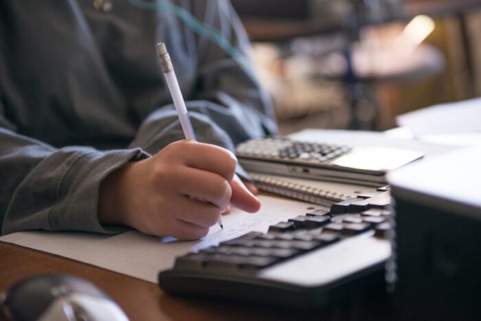 Math student writing in front of computer