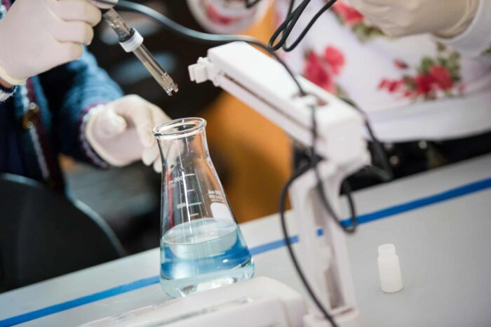 Scientists testing liquid in a flask