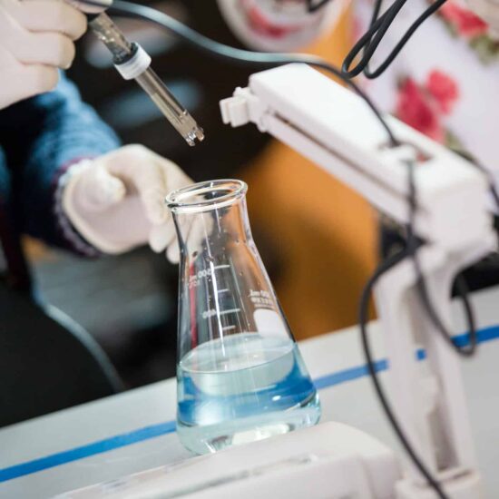 Chemist inserting sensor into a filled erlenmeyer flask