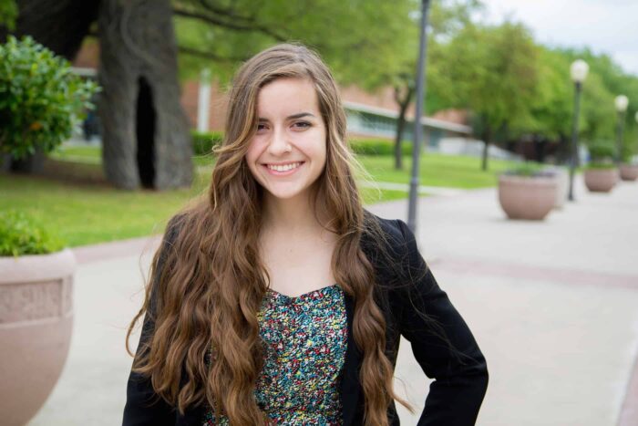 Young woman smiling in professional attire.