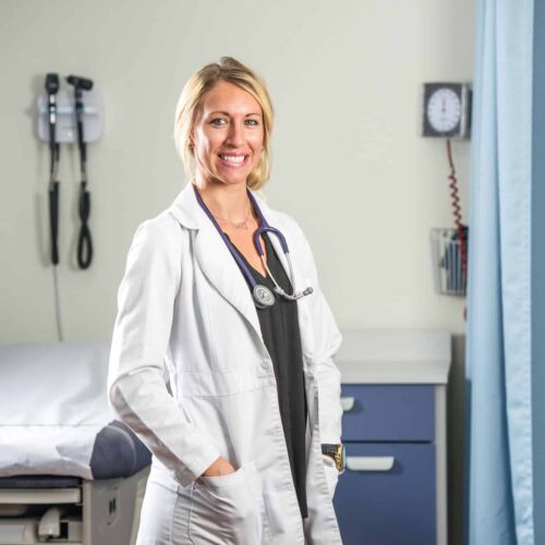 Smiling Nurse by a medical bed.