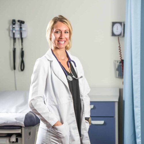 Smiling Nurse by a medical bed.