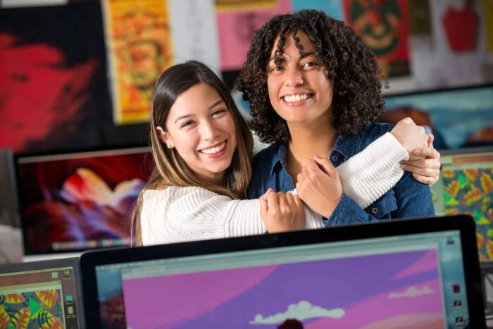 Two female students smiling in a photography class.