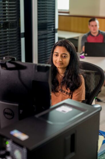 Computer science student looking at computer