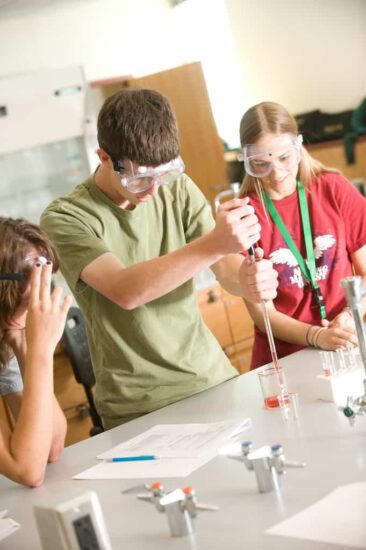 Student experiment in biology lab with two other students