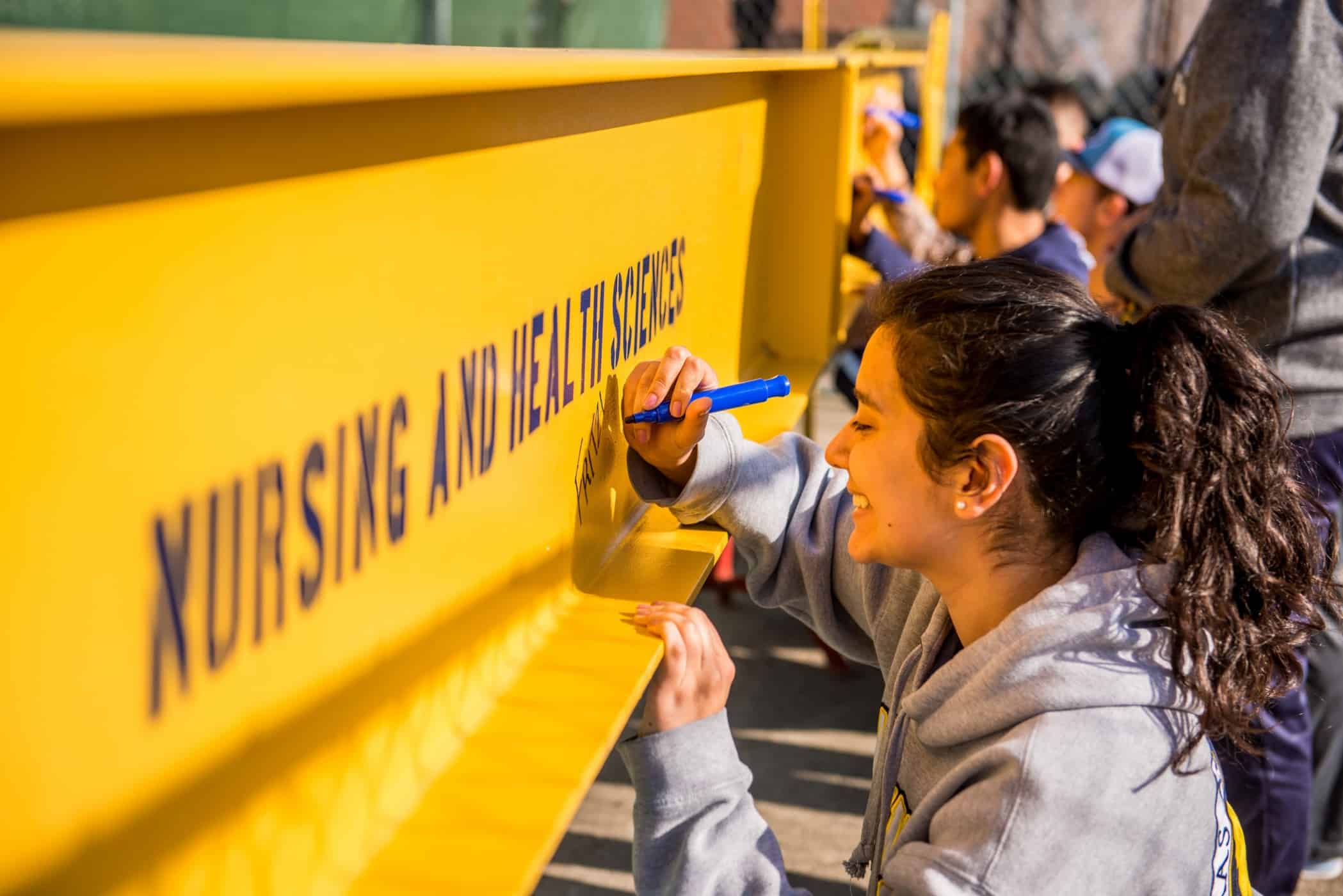 A student signing a pole.