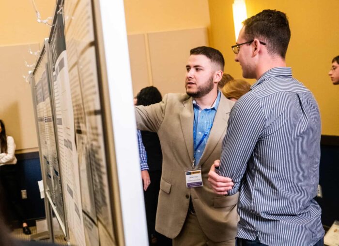 Two individual having a conversation during the annual Research Symposium.