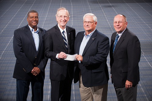 Stan McKee awarding check to Dan Jones with two other officers