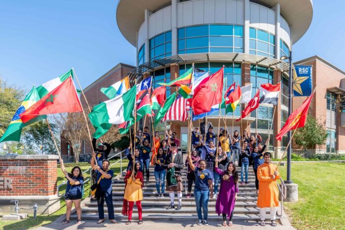 A group of student from all over the world holding their national flags in front of RSC.