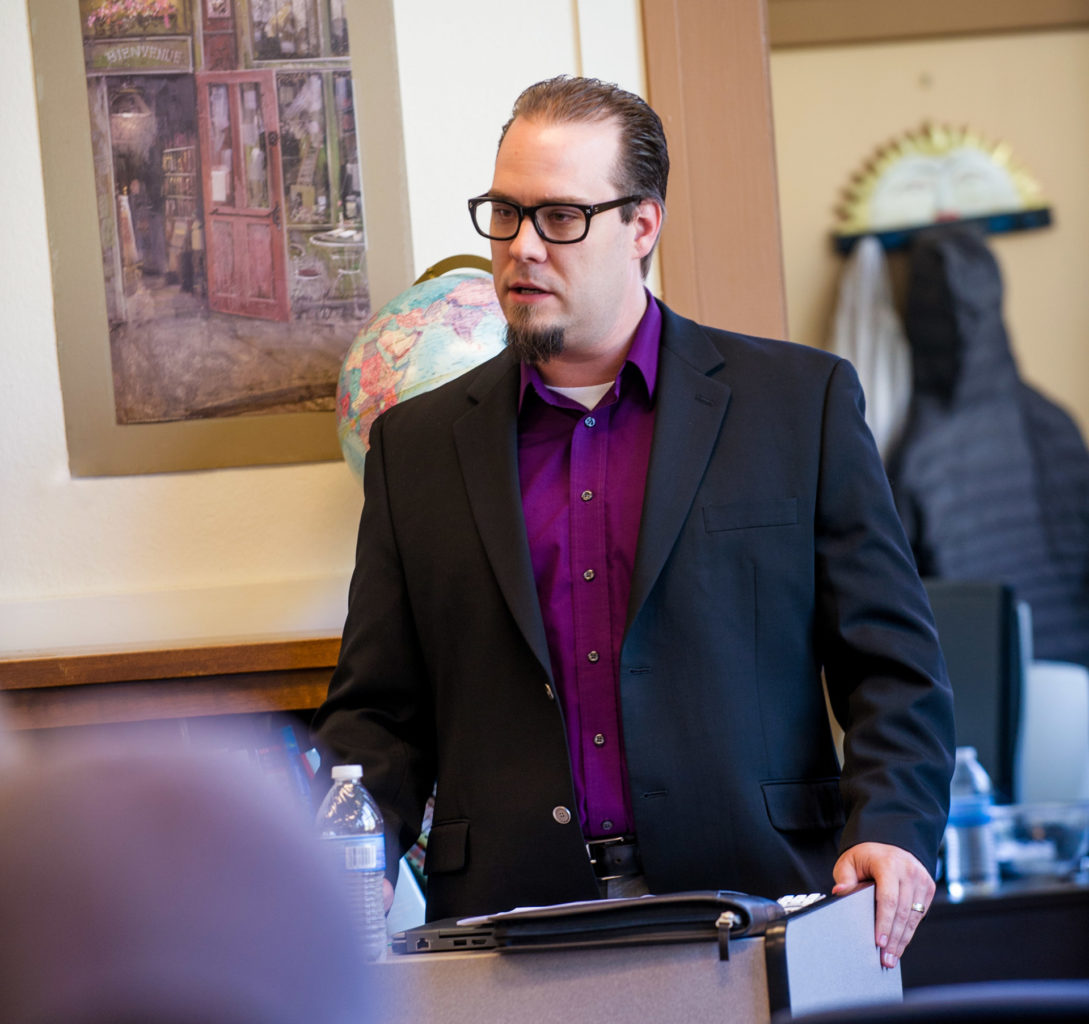 Man speaking to a classroom of individuals.