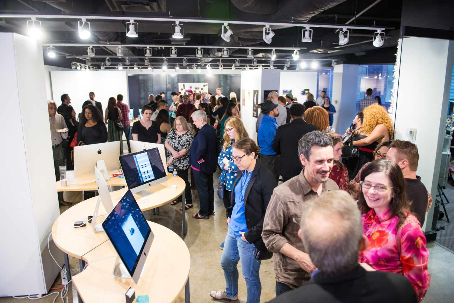 large group in art gallery with computer screens