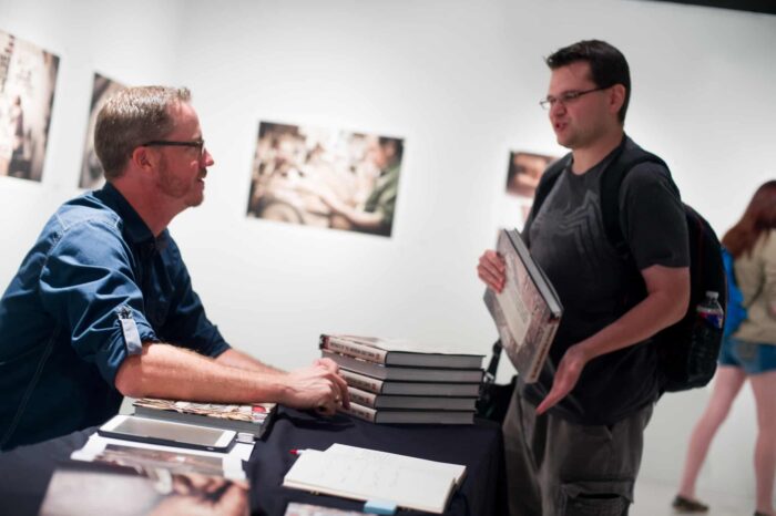 Man signing books at a book signing.