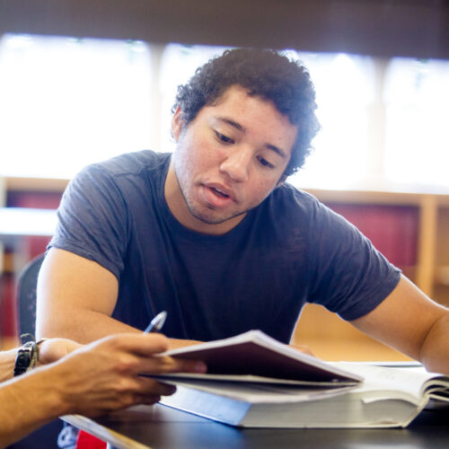 Two students reading textbooks.