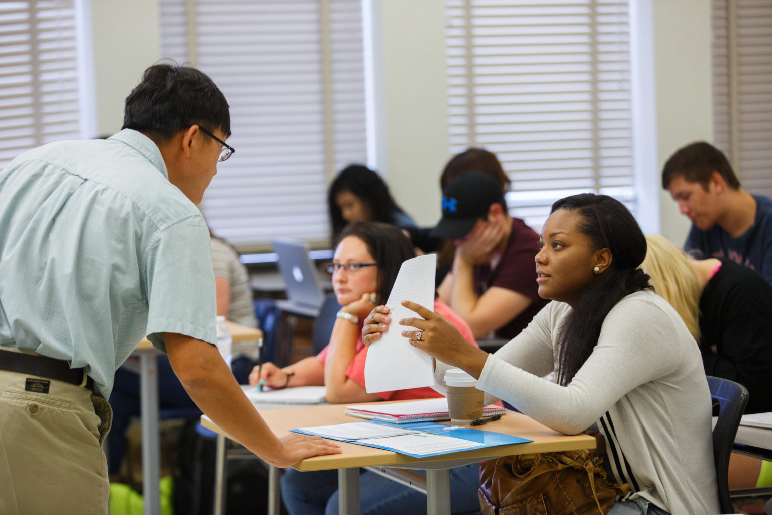 Professor speaking to a student in a liberal studies class.