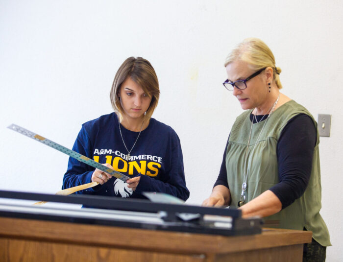 Art professor and student working on a project.