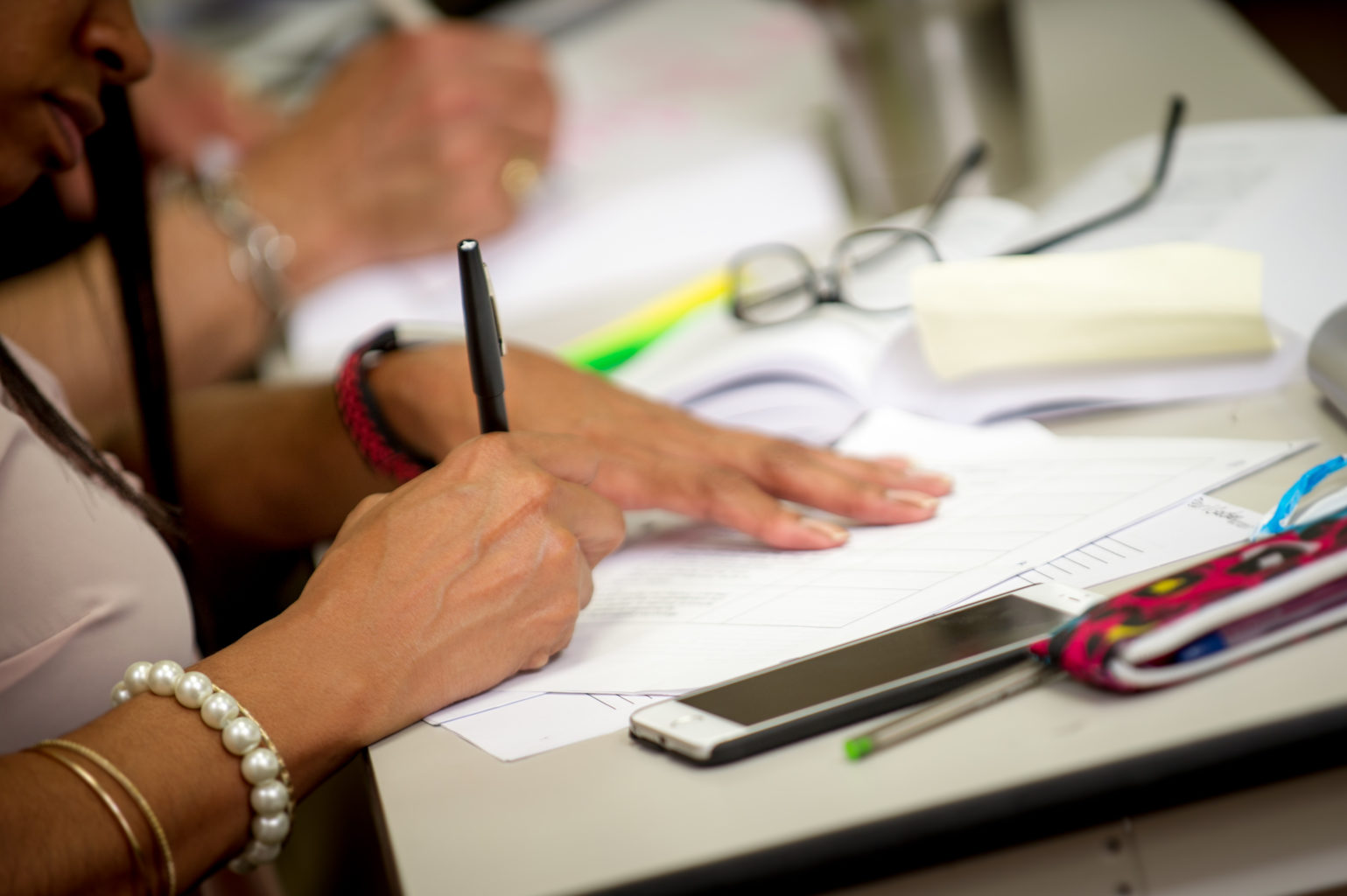 Woman's hands writing at a desk.