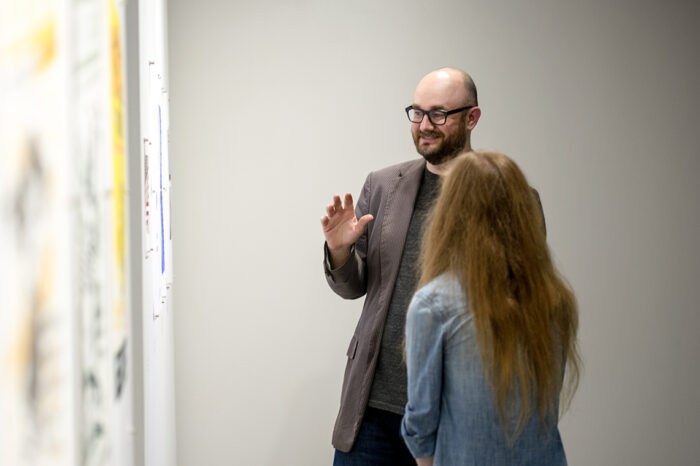 Male instructor explaining art exhibition.