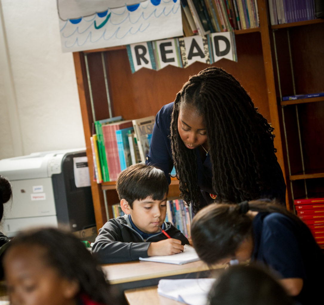 Teacher working with student with additional students in the foreground